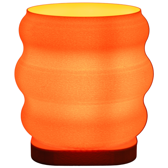 Pomarańczowa lampa The Beehive w kształcie ula, zapalona i emitująca ciepłe światło.